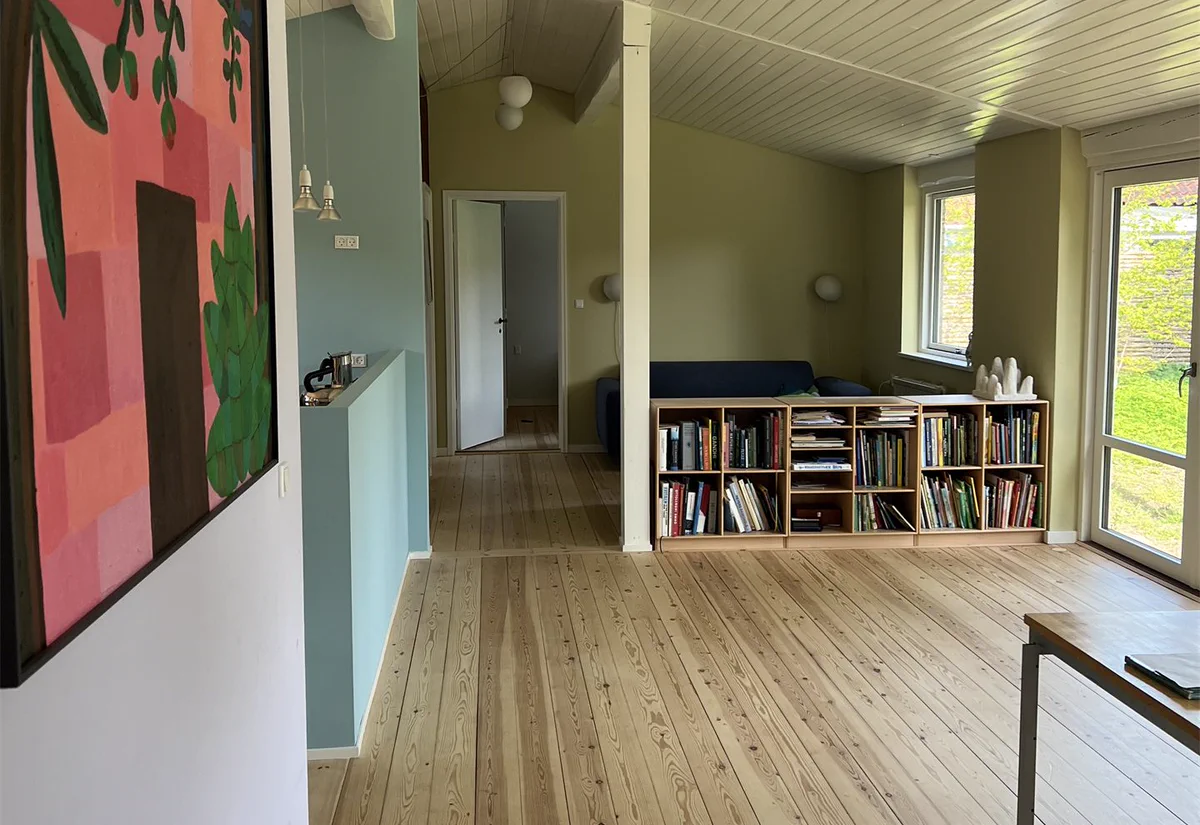 Åben stue med ny planløsning, plankegulv og malet loft efter ombygning